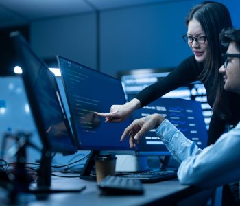 Profissionais em ambiente corporativo analisam dashboards e soluções de tecnologia corporativa, com foco em inteligência artificial, automação e transformação digital no Brasil.