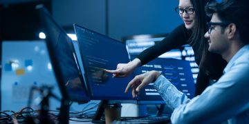 Profissionais em ambiente corporativo analisam dashboards e soluções de tecnologia corporativa, com foco em inteligência artificial, automação e transformação digital no Brasil.